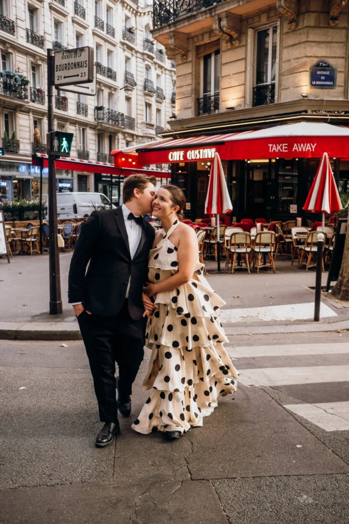 An elegant couple with polka dot dress and tuxedo kissing in Paris