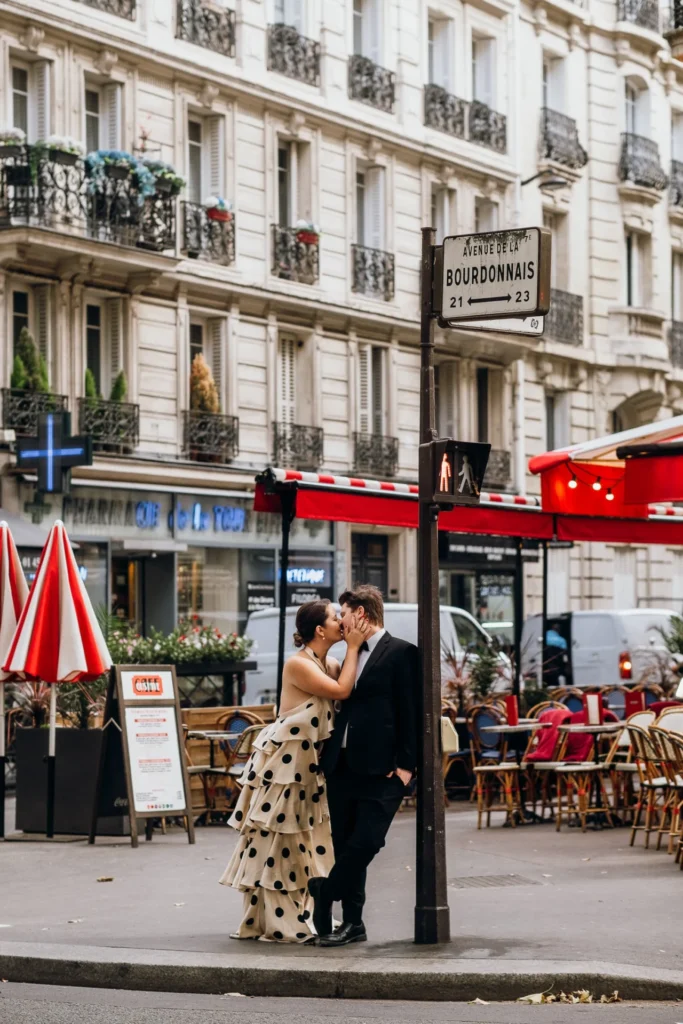 Elegant couple kissing in front of a café in Paris