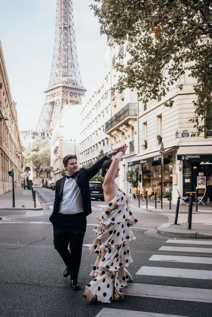 Elegant couple twirling in front of the Eiffel Tower