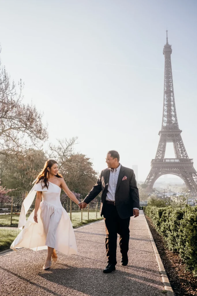 Couple walking in front of the Eiffel Tower at sunrise